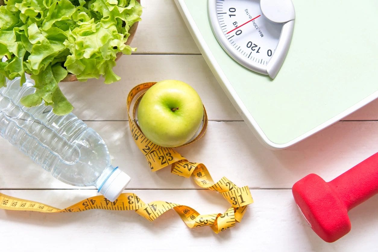 A green apple sitting on top of a scale next to water.